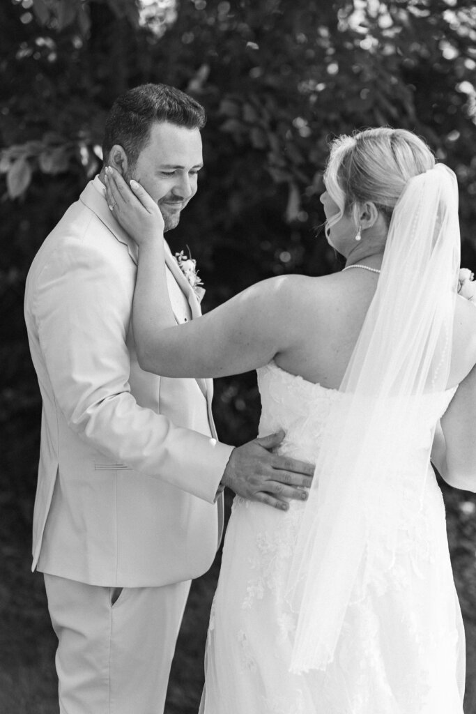 Black and white portrait of a bride and groom sharing a first look before a wedding at Lochwood Manor