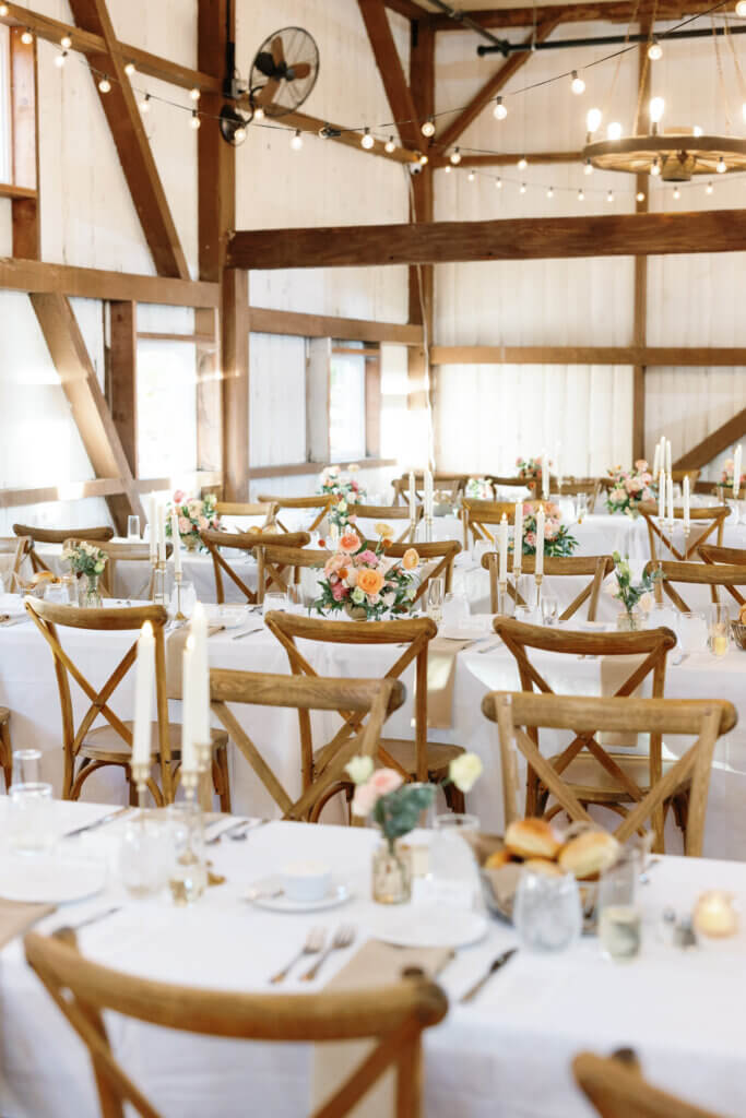 Flower arrangements on reception tables in barn venue Lochwood Manor