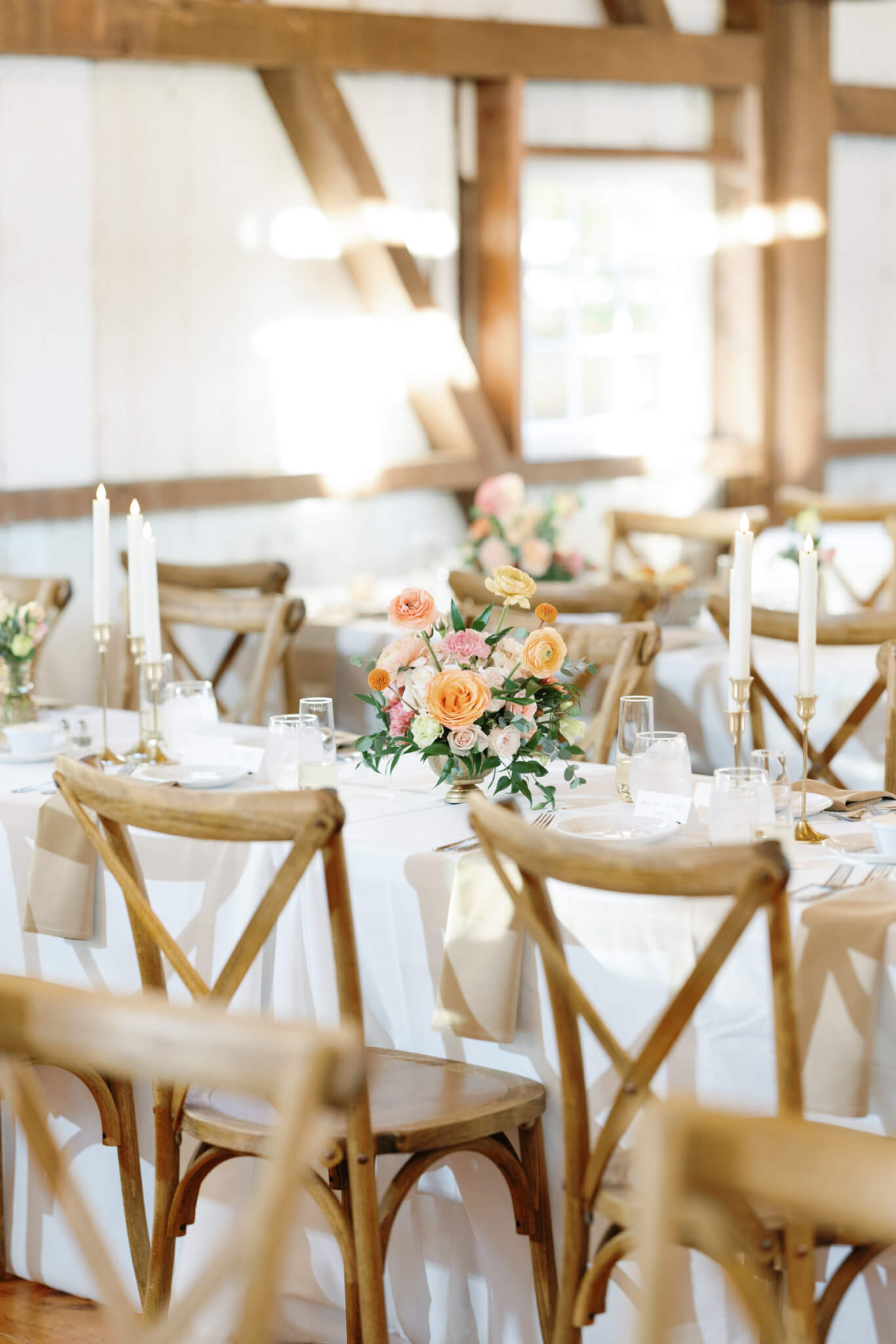 Flower arrangements on reception tables in barn venue Lochwood Manor